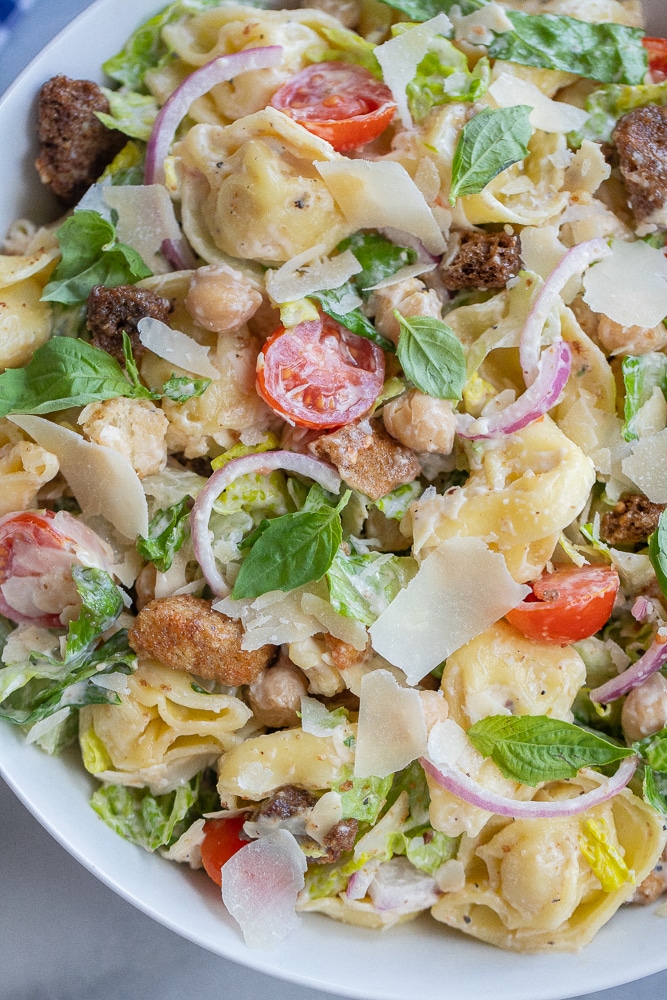 close up of tortellini caesar salad pasta with croutons and chickpeas