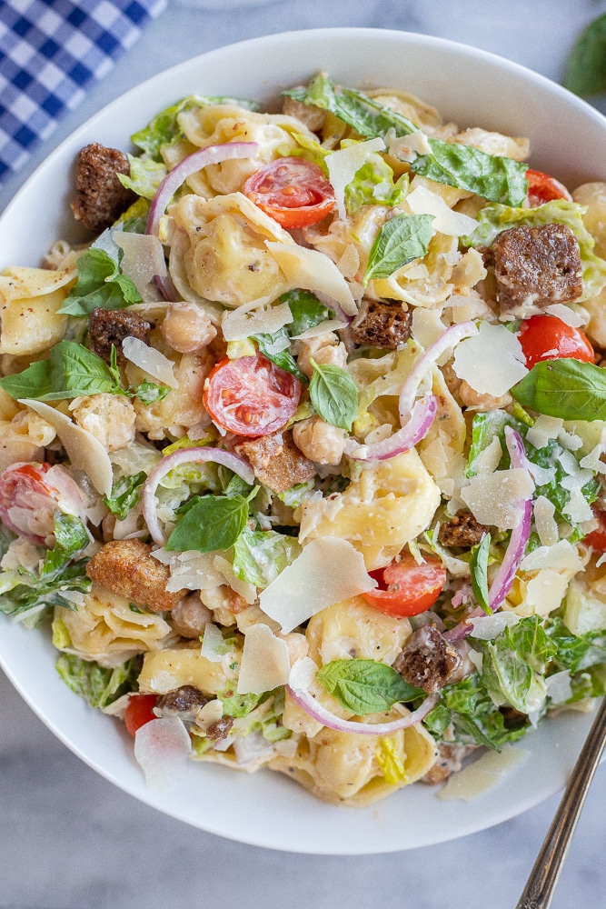 serving bowl full of cheese tortellini caesar salad with croutons