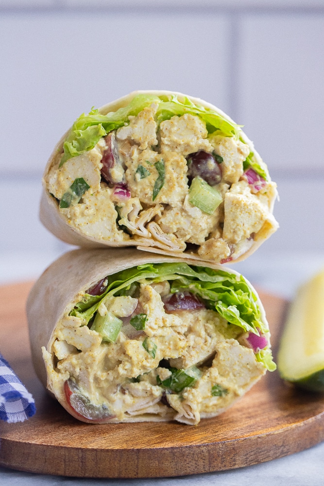 vegan curry tofu wraps on a cutting board with a pickle