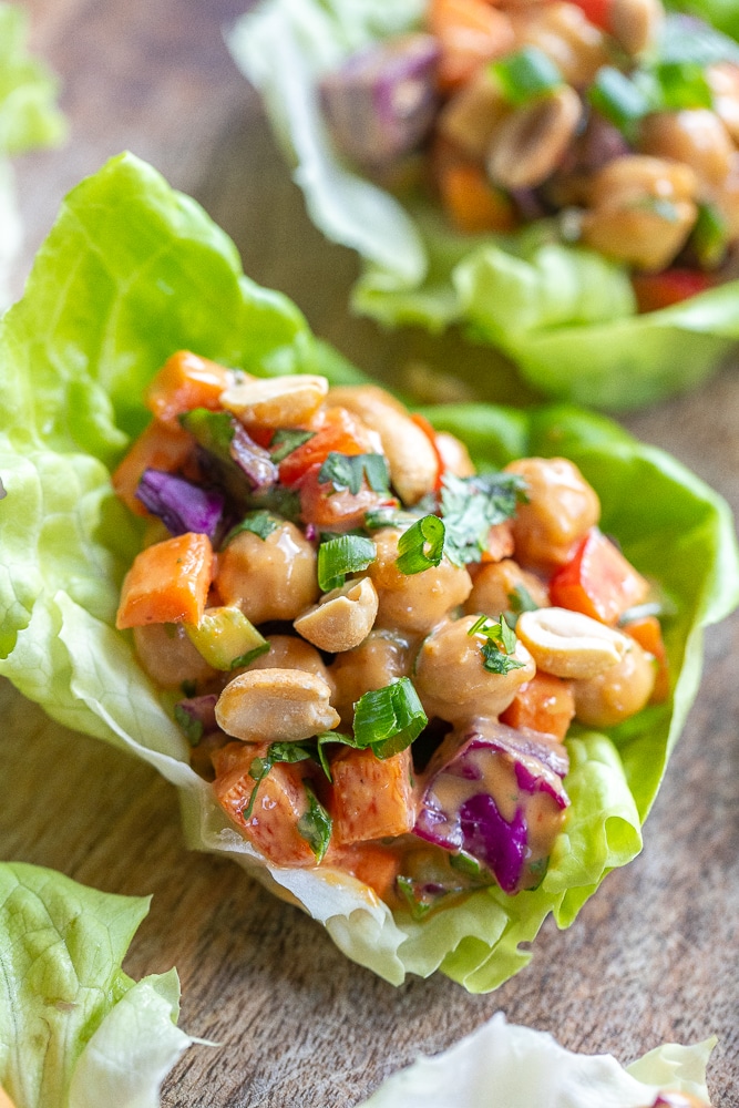 close up of a chickpea lettuce wrap with peanut sauce and veggies