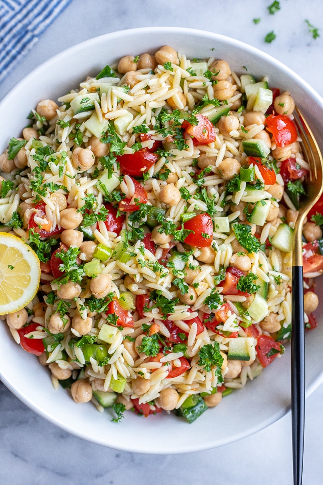 serving bowl full of tabouli inspired orzo salad with chickpeas and lemon