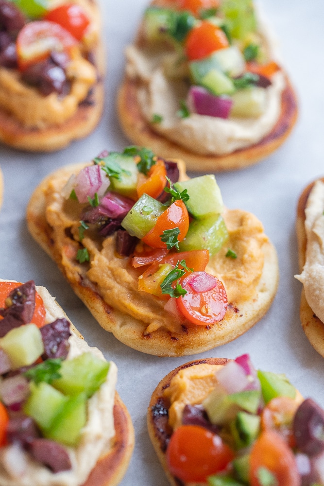 close up of a naan bread appetizer with hummus and veggies