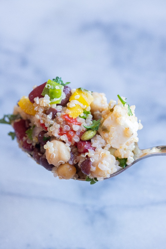 spoon filled with three bean quinoa salad