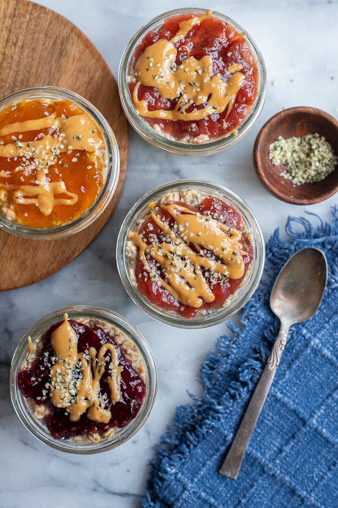 different flavors of peanut butter and jelly overnight oats topped with hemp hearts