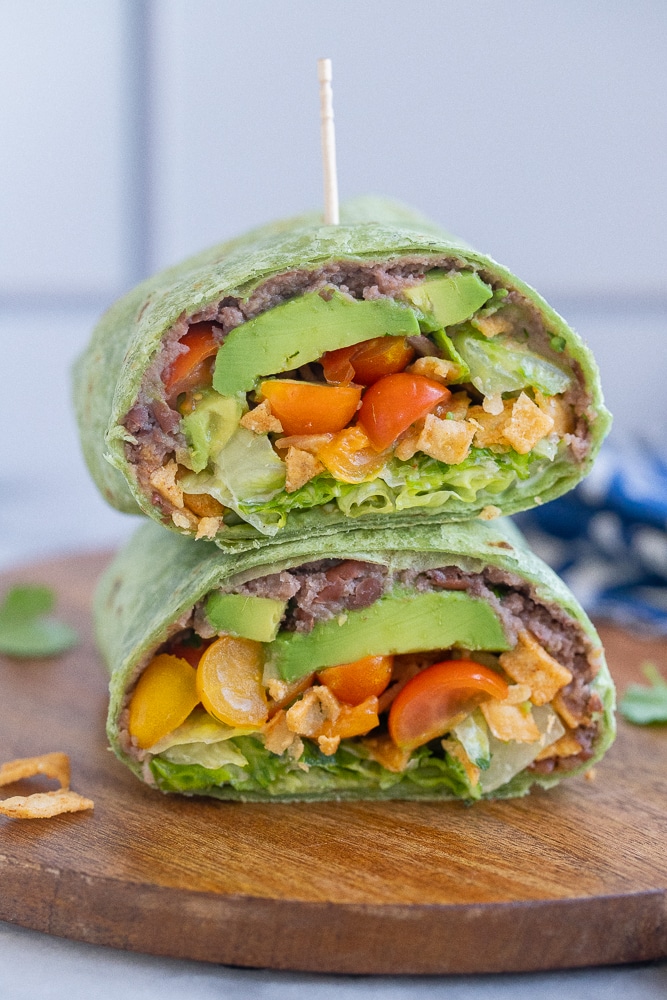 healthy black bean ranch wrap cut in half on a cutting board