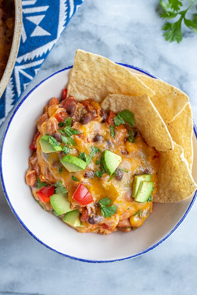 bowl full of cheesy taco casserole in a bowl with some chips