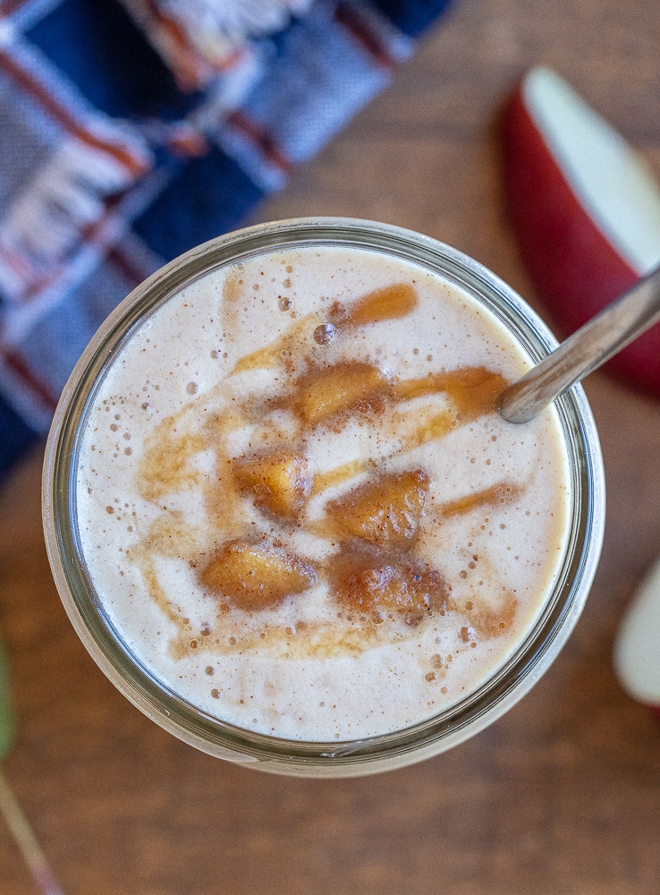 close up of a caramel apple smoothie in a mason jar with a metal straw