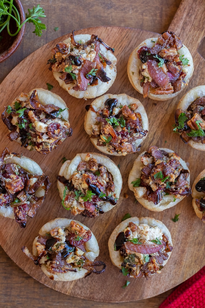 cutting board filled with balsamic onion and goat cheese puff pastry bites