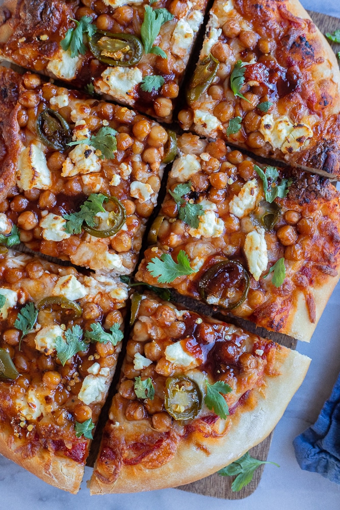 vegetarian bbq chickpea pizza sliced up on a cutting board