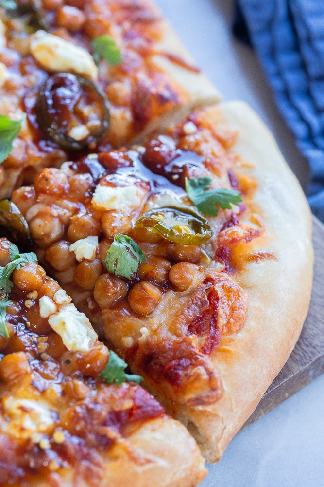 close up of a slice of sweet and spicy chickpea pizza with goat cheese