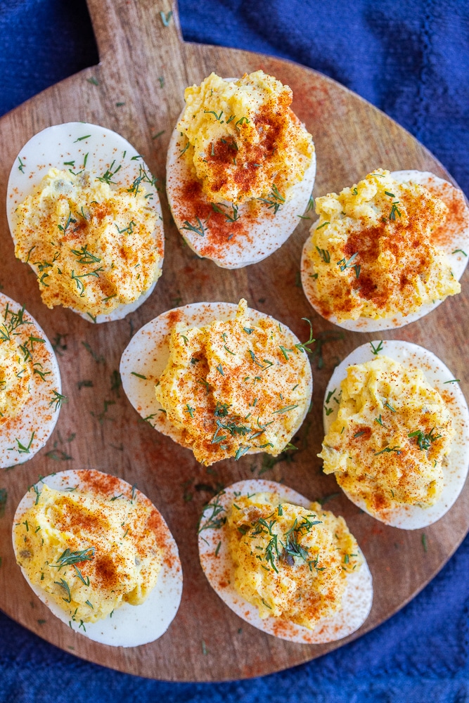 a small wooden cutting board filled with the best deviled eggs