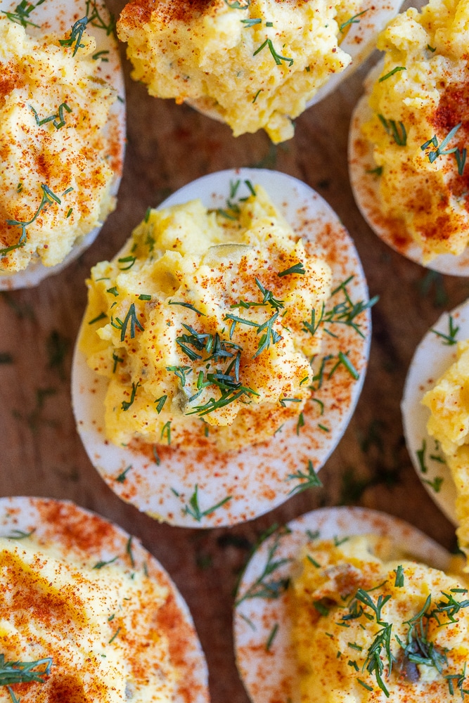 close up of a dill pickle deviled egg topped with paprika