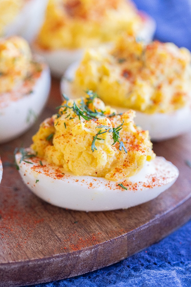 close up of a dill deviled egg on a cutting board