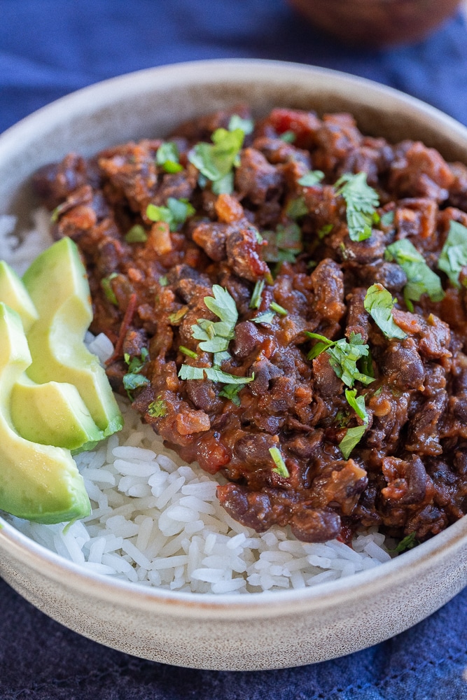 chipotle black beans in a bowl of rice with avocado