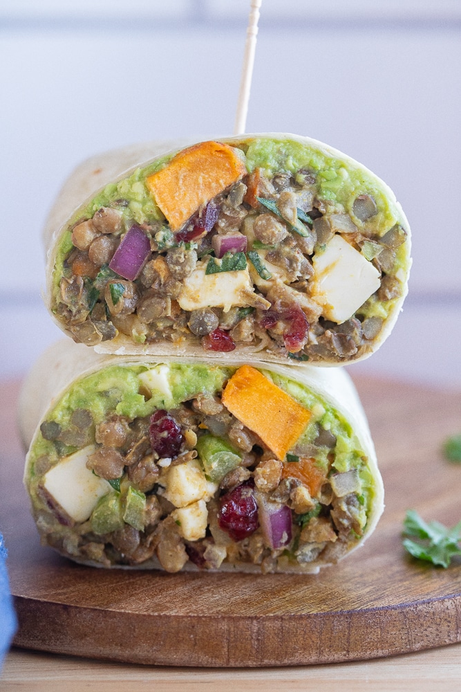 vegetarian lentil wrap cut in half and stacked on a cutting board