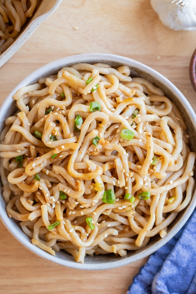 vegetarian garlic noodles in a bowl with a blue napkin