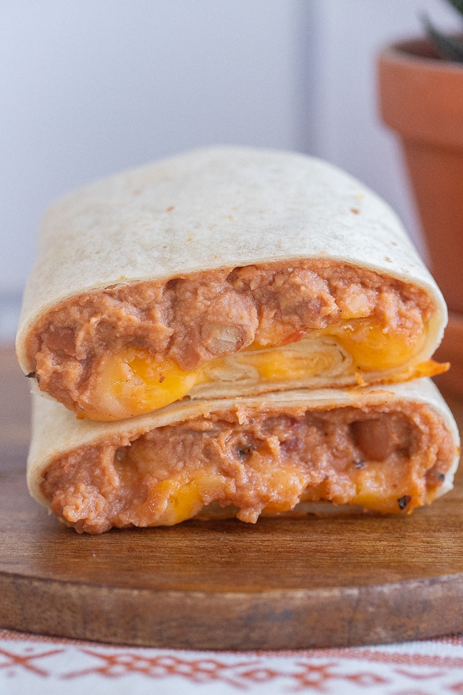 bean and cheese burrito cut in half on a cutting board