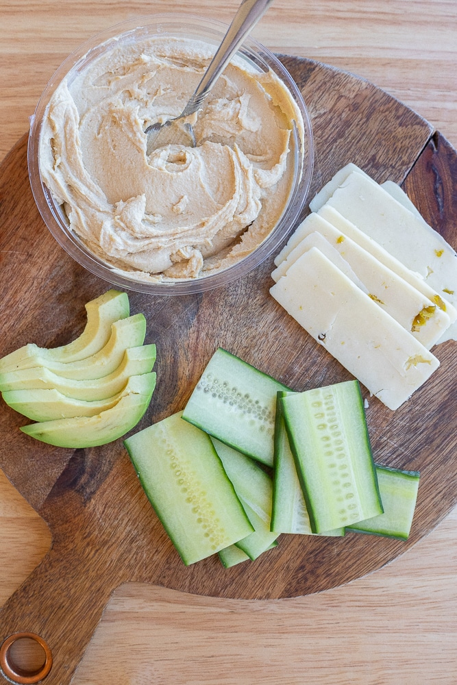 showing ingredients needed to make this hummus and avocado sandwich with cucumber and cheese