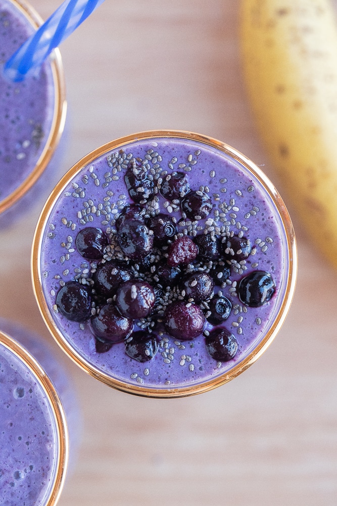 close up of a glass of wild blueberry banana smoothie